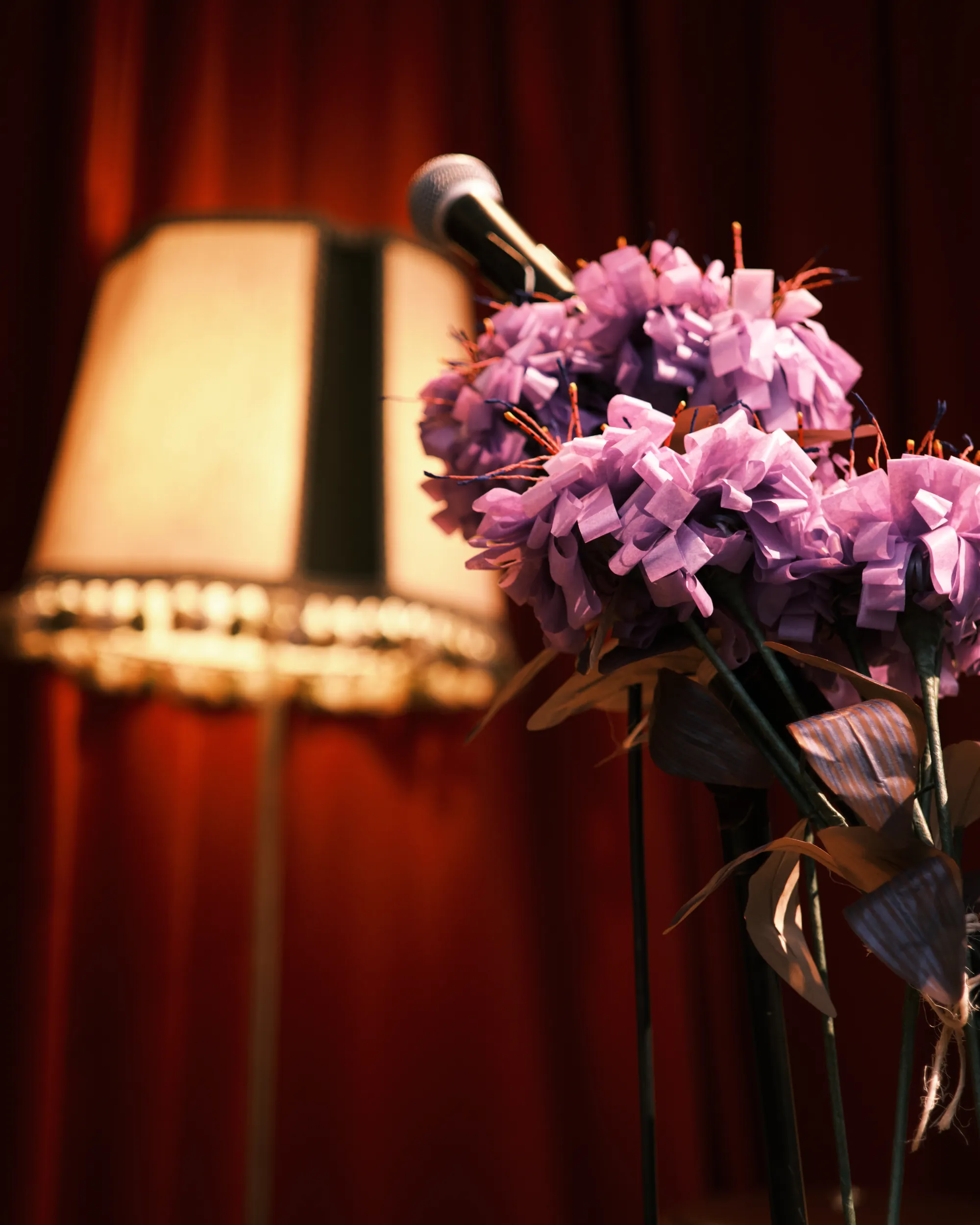 La scène d'un bœuf, un rideau rouge, une lampe, des fleurs en papier et un micro